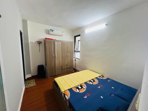 a small bedroom with a bed with a blue comforter at Tom coffee and home stay in Thôn Mỹ Phước