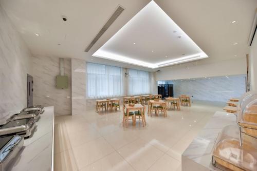 eine Küche mit einem Esszimmer mit Tischen und Stühlen in der Unterkunft Starway Hotel Shanghai Qibao Hongqiao Railway Station in Shanghai