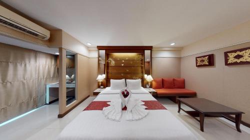 a hotel room with a large bed and a couch at Mariya Boutique Hotel At Suvarnabhumi Airport in Lat Krabang