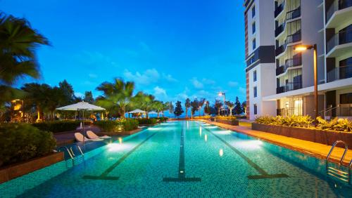 a swimming pool in a hotel at night at Timurbay Residences in Kuantan