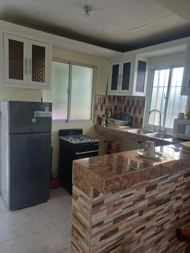 uma cozinha com geladeira e fogão em Dona Beba Guesthouse em La Caleta