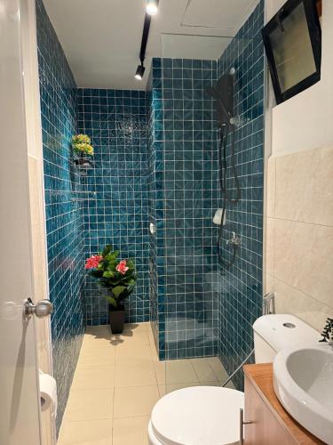 a blue tiled bathroom with a shower and a toilet at Condo unit with balcony in Lapu Lapu Cebu in Mactan Island