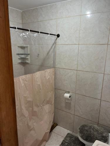 e bagno con doccia, servizi igienici e carta igienica. di Pousada Azul a Penha