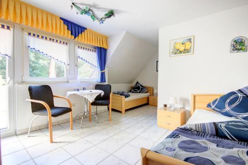 Schlafzimmer mit einem Bett, einem Tisch und Stühlen in der Unterkunft Pension Büürma in Papenburg