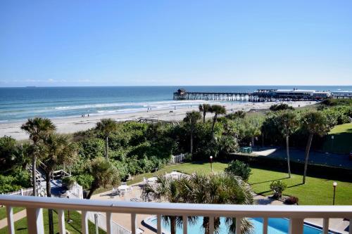 a view of a beach and the ocean with a pier at Cocoa Beach Towers - Oceanfront Resort with Heated Pool, Tennis Steps from the Pier in Cocoa Beach