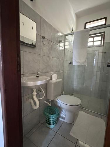 a bathroom with a toilet and a sink at Apartamentos completos no centro - vista mar in Mucuri
