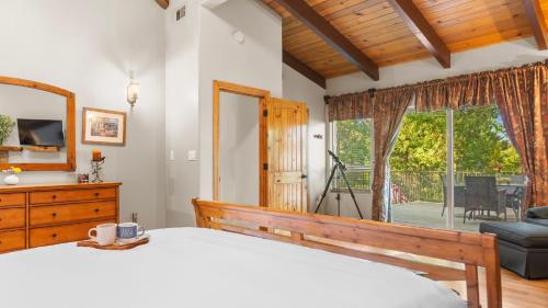 a bedroom with a bed and a large window at The Fairway Hideaway by AvantStay Game Room Outdoor Dining Near Lake Arrowhead in Lake Arrowhead