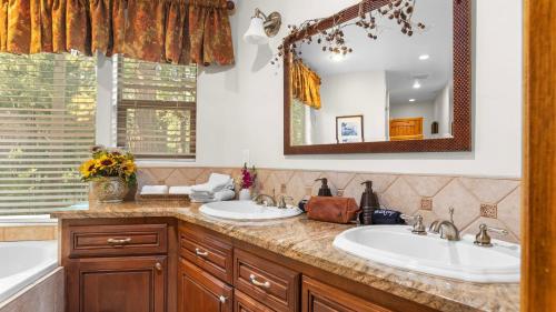 a bathroom with two sinks and a mirror at The Fairway Hideaway by AvantStay Game Room Outdoor Dining Near Lake Arrowhead in Lake Arrowhead