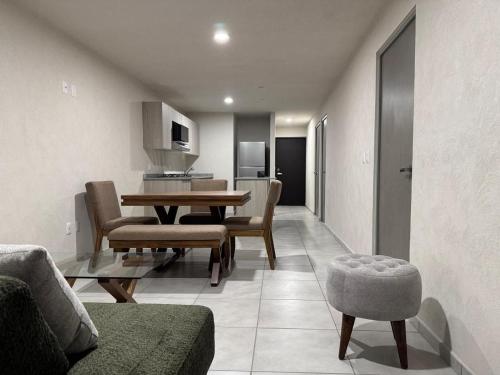 a living room with a table and chairs and a kitchen at New apartment near H. Civil Viejo with A/C in Guadalajara