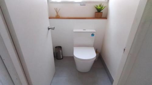 een kleine badkamer met een toilet en een raam bij Beachway in Orient Point