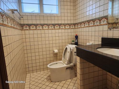 a bathroom with a toilet and a sink at Ben's House Bangsaen in Bangsaen
