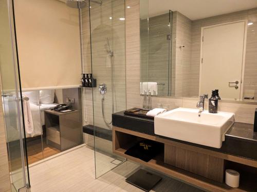 un baño con lavabo y ducha en The Grand Platinum Jakarta, en Yakarta