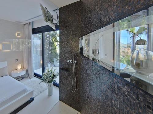 a bathroom with a shower and a large window at Villa in Ibiza with Infinity Pool and Sea Views in Es Cubells
