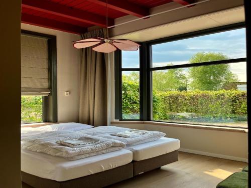 a bedroom with a bed and a large window at Group accommodation for 36 guests in Scherpenzeel
