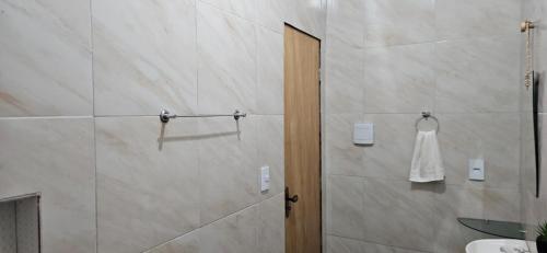 een badkamer met een douche en een witte jurk die aan de muur hangt bij Chalé Viçosinha de Açúcar in Viçosa do Ceará