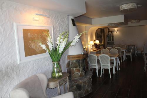 a restaurant with a table and chairs and a vase of flowers at Feniks Agro&Spa Adults Only in Świnoujście