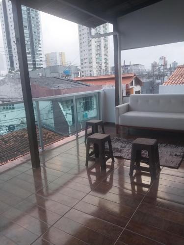 a living room with a couch and two stools at Villa Hostel in Belém