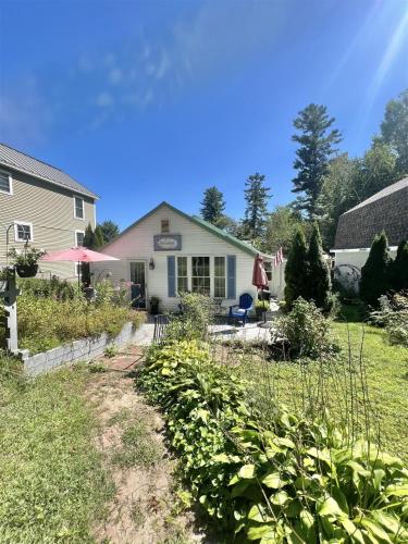 un giardino di fronte a una casa di PINE TREE COTTAGE LIMIT 5 cottage a East Sebago