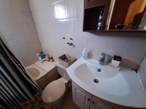 um banheiro com um vaso sanitário branco e uma pia em Cabaña en el Canelillo em Algarrobo