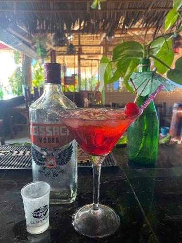a drink sitting on a table next to a bottle of alcohol at Satosa Beach Resort in San Joaquin