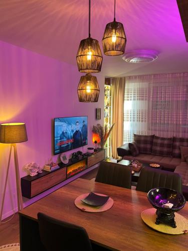 uma sala de estar com iluminação roxa e uma mesa de madeira em The Hot Spot em Kosovo Polje