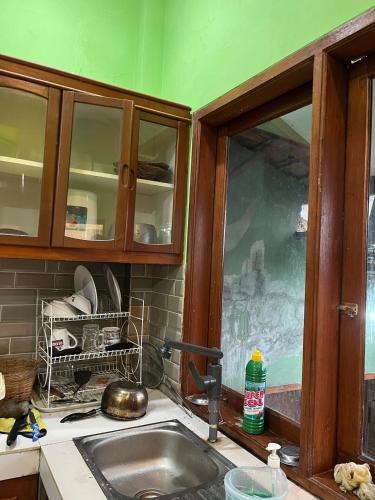 a kitchen counter with a sink and a window at Villa Murah Joglo Sariwangi in Cihanjuang 1