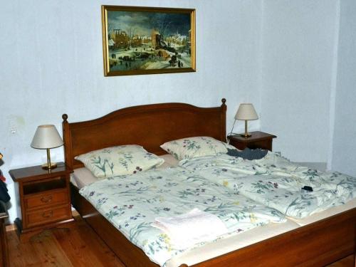 uma cama num quarto com dois candeeiros e um quadro em Berg Castle Klösterle em Zedlitzdorf