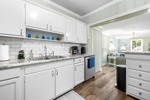 a kitchen with white cabinets and a sink at Hay House- Adorable and updated home! in Fayetteville