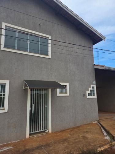 una casa grigia con una porta e un garage di Pousada Alvorada a Engenheiro Coelho