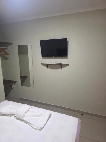 una stanza con una TV a schermo piatto su una parete di Pousada Alvorada a Engenheiro Coelho