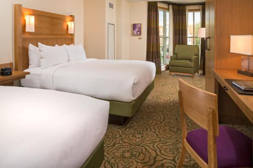 a hotel room with two beds and a desk at The Inn At Swarthmore in Swarthmore