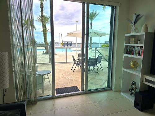 a living room with sliding glass doors with a view of a patio at Luxury 2BR in Downtown Fort Myers Pool & Terrace in Fort Myers