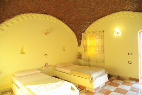 Dos camas en una habitación con techo abovedado. en oasis panorama hotel, en Bawati