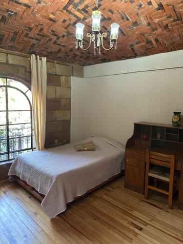 a bedroom with a bed and a wooden ceiling at Casa Rústica del pedregal in Mexico City