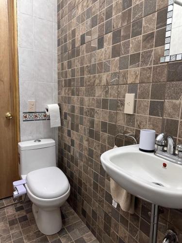 a bathroom with a toilet and a sink at Casa Rústica del pedregal in Mexico City