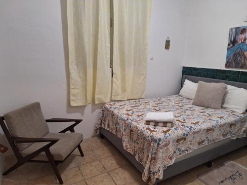 a small bedroom with a bed and a chair at Humacao Guest House 4 in Humacao