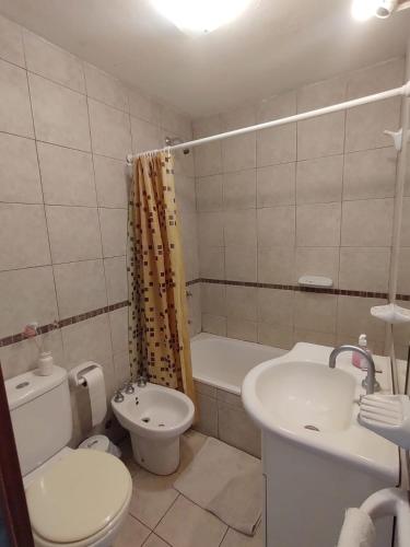 a bathroom with a white toilet and a sink at Torre 1 Estadio Unico in La Plata