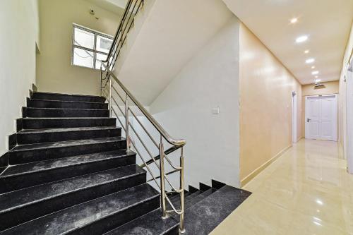 a staircase in a house with black stairs and a window at Hotel O Poddar Inn in Dispur