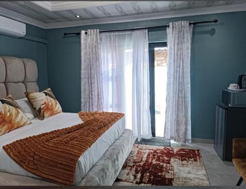 De Rams boutique guest house : غرفة نوم بها سرير ونافذة كبيرة