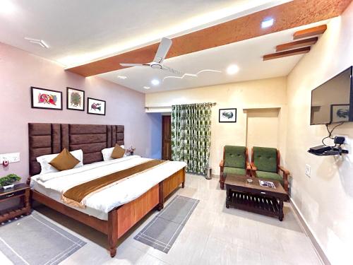 Tiger Heaven Resort في Tāla: غرفة نوم بسرير كبير وكرسيين اخضر