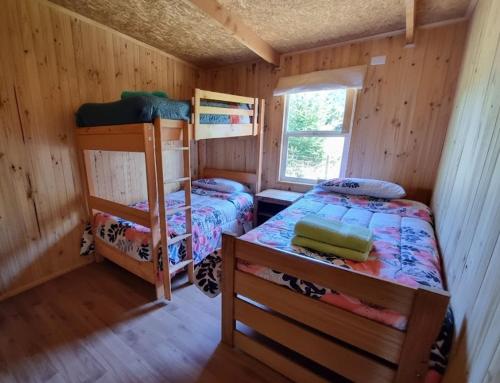 um quarto com dois beliches em uma cabana em Cabaña Alto Puelo em Puelo