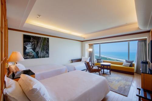 a hotel room with two beds and a large window at Phoenix Seagaia Ocean Tower in Miyazaki