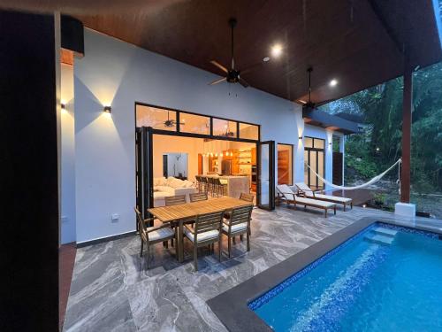 Villa 10 at Chial Reserve Exclusive Jungle Retreat في Big Eddy: فيلا مع مسبح وغرفة طعام