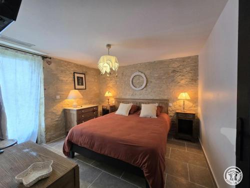 a bedroom with a bed and two tables and two lamps at Maison en pierres au cœur du Périgord, 10 personnes, charme authentique - FR-1-616-508 in LʼAir
