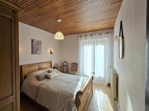 a bedroom with a bed and a wooden ceiling at Maison de campagne confortable en Dordogne - FR-1-616-521 in Lala