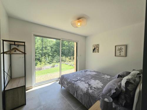 a bedroom with a bed and a large window at Charmante maison avec piscine chauffée privée au cœur du Périgord Noir - FR-1-616-530 in Prats-de-Carlux