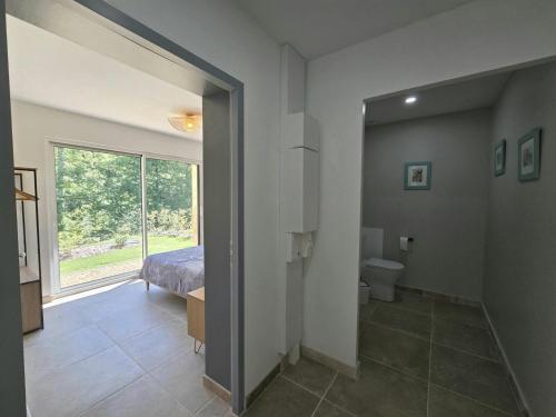 a bedroom with a bed and a bathroom with a window at Charmante maison avec piscine chauffée privée au cœur du Périgord Noir - FR-1-616-530 in Prats-de-Carlux