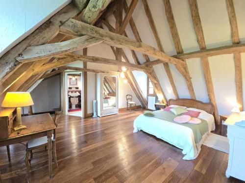 Dormitorio con cama y escritorio en el ático en Charmante maison à Hautefort avec piscine privée, animaux admis - FR-1-616-514, en Boisseuilh