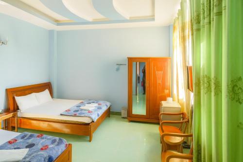 a bedroom with two beds and a chair in it at Như Quỳnh Hotel HCM in Ho Chi Minh City