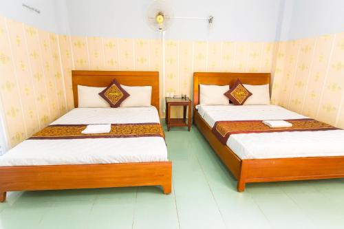 two beds in a room with two beds sidx sidx at Như Quỳnh Hotel HCM in Ho Chi Minh City